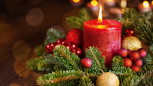Brennende Kerze in der festlichen Weihnachtsanordnung